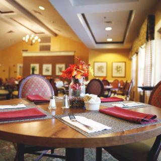 A cozy restaurant interior with neatly set tables and warm lighting.