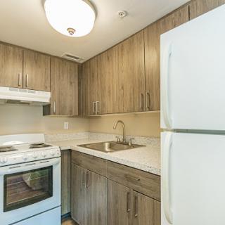 A contemporary kitchen featuring wooden cabinetry and essential appliances.