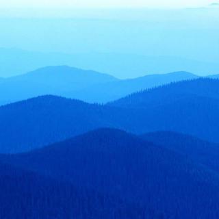 A serene view of layered blue mountains stretching into the horizon.