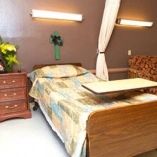 A hospital room with a bed and bedside furniture.