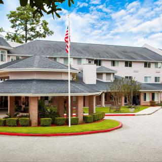 A residential building with a circular driveway and an American flag out front.