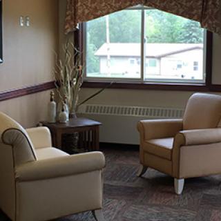 A cozy living room with two armchairs positioned near a window.