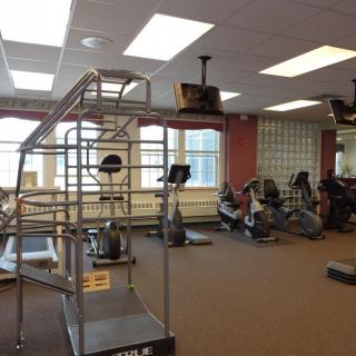 An empty gym with various exercise equipment including treadmills and stationary bikes.