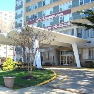 Entrance of a residential apartment building with landscaped surroundings.