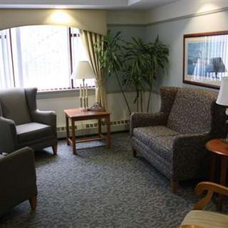 A cozy living room area with a sofa, armchairs, and coffee tables.