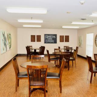 A spacious dining area featuring wooden furniture and decorative wall art.