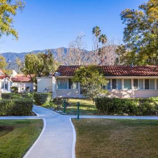 A residential area with a garden and pathway, set against a backdrop of mountains.
