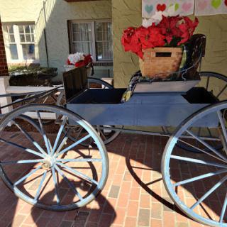 A charming vintage wagon adorned with a basket of vibrant flowers.