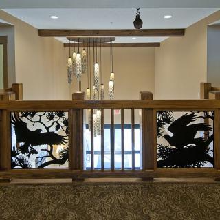 A modern interior space featuring intricate wooden railing designs and a stylish chandelier.