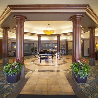 Luxury hotel lobby with a grand piano and elegant decor.