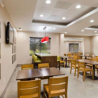 A modern dining area featuring wooden tables and chairs, with bright lighting and a cozy atmosphere.