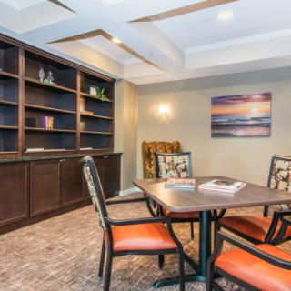 A cozy meeting room with a table, chairs, and a built-in bookshelf.