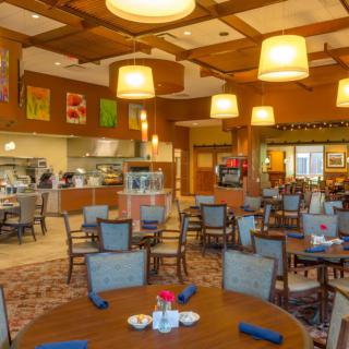 A cozy restaurant interior with tables and chairs, warm lighting, and a welcoming atmosphere.