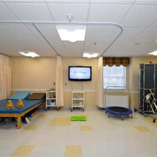 A physical therapy room equipped with exercise tools and a TV for rehabilitation activities.