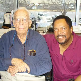 Two men sitting together in an office setting.