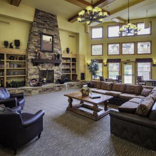 Spacious living room with a rustic fireplace and large windows.