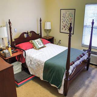 A cozy bedroom with a four-poster bed, bedside tables, and decorative elements.