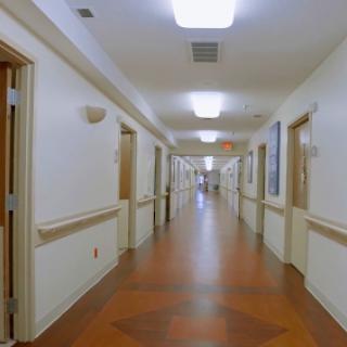 A bright and spacious hospital hallway, featuring doors on either side.