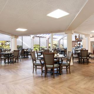 A spacious and well-lit dining area with several tables and chairs arranged for guests.
