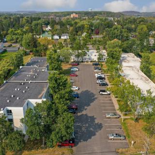 Aerial view of a parking lot surrounded by buildings and trees, showcasing an urban landscape.