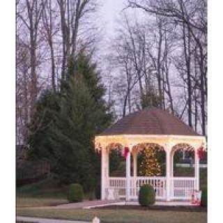 A decorated gazebo illuminated with lights in a winter setting during the evening.