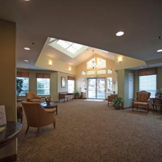 A spacious and well-lit lobby area with comfortable seating and large windows.