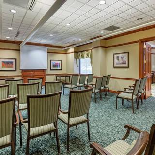 A conference room set up with chairs facing a projector screen, ready for a presentation.