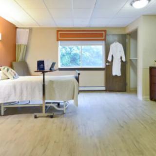 A clean and modern hospital room featuring a single bed, a window, and medical equipment.