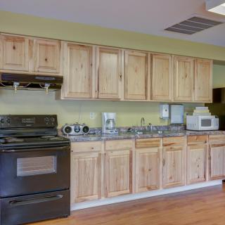 A kitchen featuring wooden cabinets and a variety of appliances, including a stove and microwave.