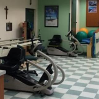 A physical therapy room with stationary bikes and exercise equipment.