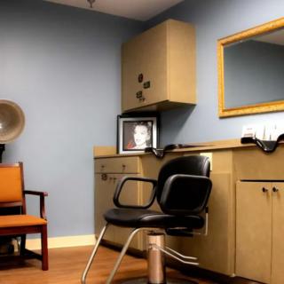 Cozy hair salon with styling chair and mirror.