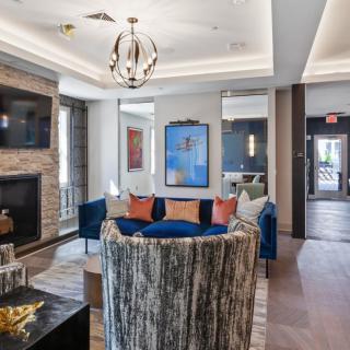 A modern living room with a fireplace, elegant seating, and stylish decor.