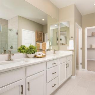 A modern bathroom featuring a spacious vanity with double sinks and ample storage.