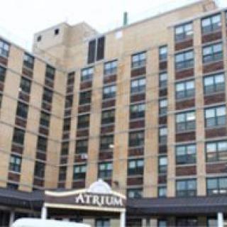 A multi-story brick hospital building with an entrance labeled 'Atrium'.