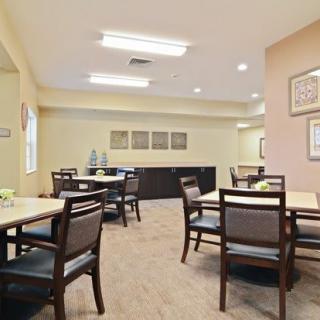 A well-lit dining area with neatly arranged tables and chairs, featuring modern decor and a cozy atmosphere.