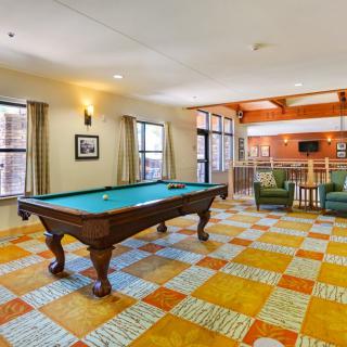 A spacious game room featuring a pool table and a comfortable seating area.