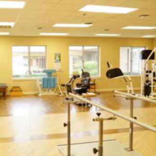 A physical therapy room equipped with various exercise machines and equipment.