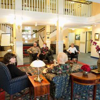 A group of people engaging in conversation in a cozy indoor seating area.