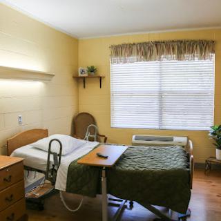 A cozy hospital patient room with a bed, window, and comforting decor.