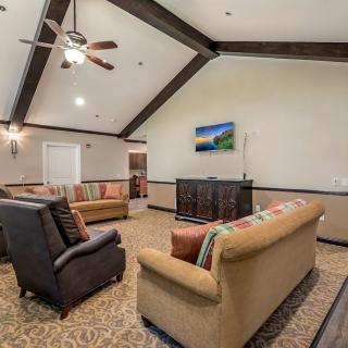 A spacious living room with cozy seating and a vaulted ceiling.