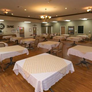 An empty dining room with neatly arranged tables and chairs.
