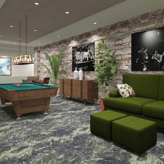 A stylish game room featuring a pool table, green sofa, and decorative stone walls.