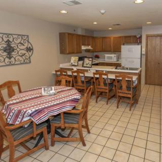 A cozy kitchen and dining area with a wooden table, chairs, and traditional appliances.