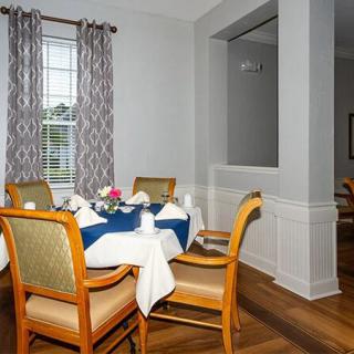 A cozy dining room with a neatly set table and elegant decor.