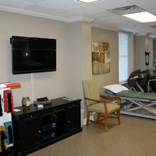 A modern office interior with a television, artwork, and comfortable seating.