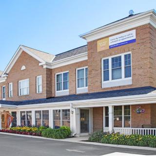 A brick commercial building with multiple windows and a landscaped entrance.