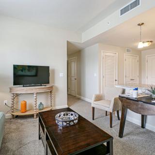 A modern living room with a television, coffee table, and seating area.