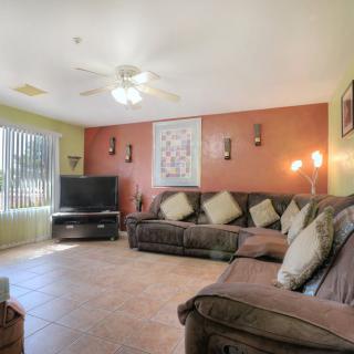 A cozy living room with a large sofa, television, and decorative elements.