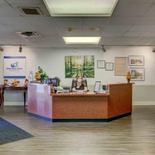 A spacious office reception area with a central desk and welcoming atmosphere.