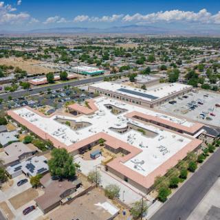 An aerial view of a community building surrounded by residential areas and commercial spaces.